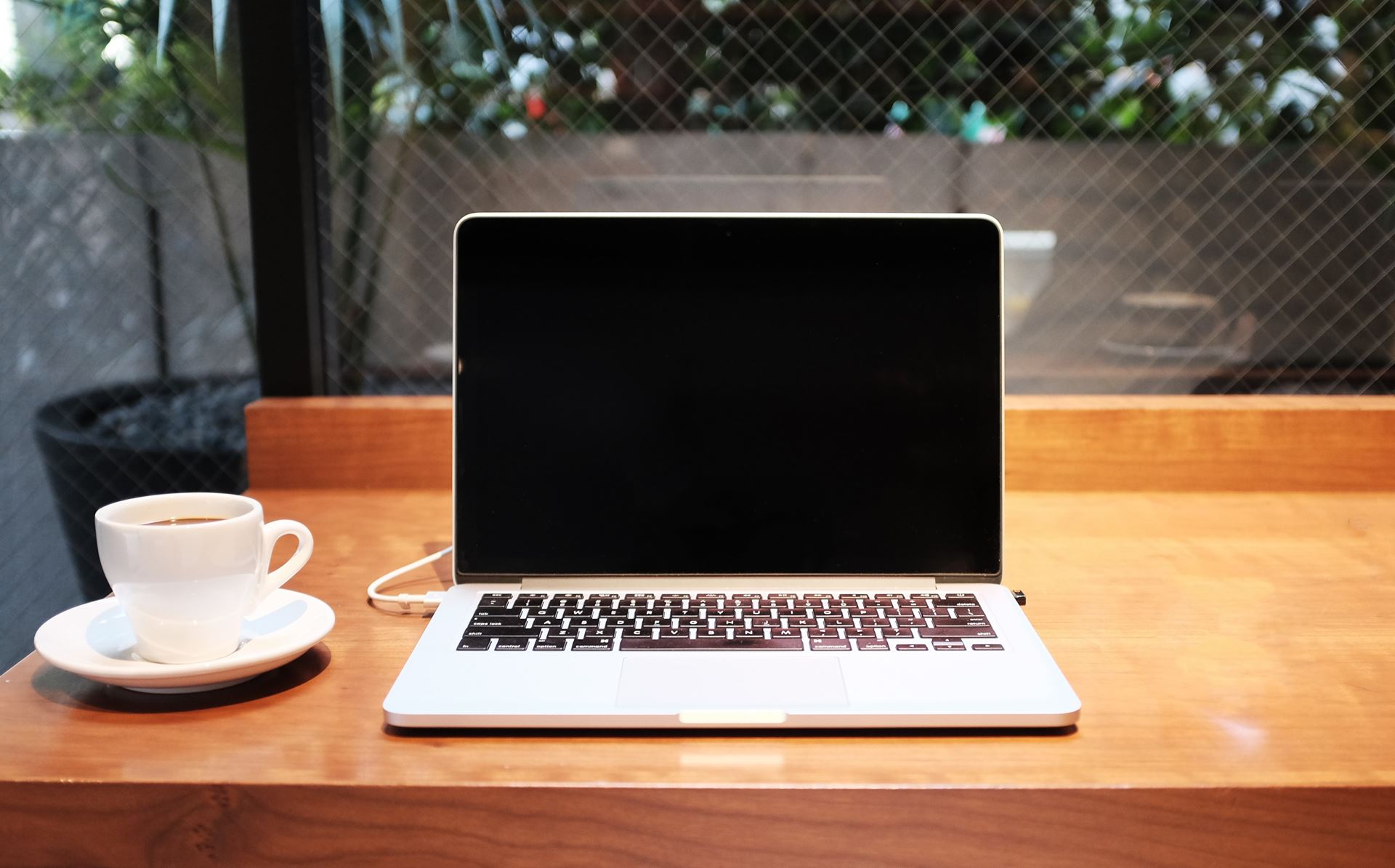 an open laptop computer sitting on top of a wooden table